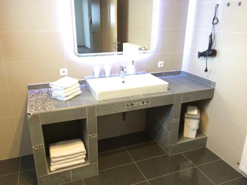 ein Bad mit einem Waschbecken und einem Spiegel in der Unterkunft Glaneggerhof in Glanegg