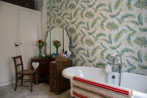 a bathroom with a bath tub and a mirror at Newberry Beach lodge in Combe Martin