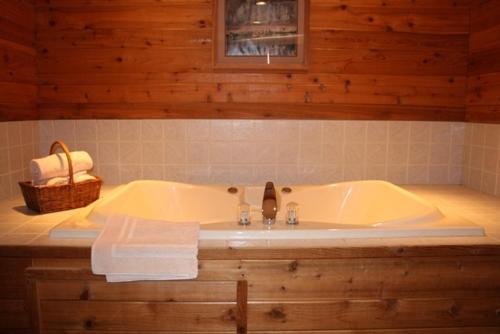 a bathroom with a tub and a basket of towels at The Lodge at Crooked Lake in Siren