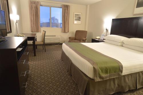 a hotel room with a bed and a chair at The Madison Inn in Spokane