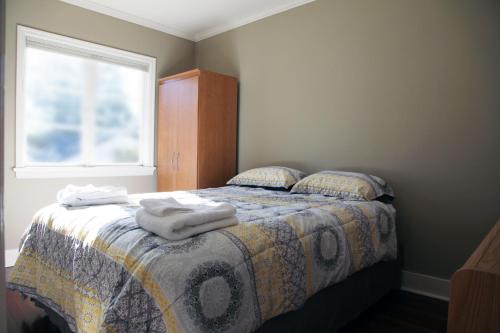 um quarto com uma cama com toalhas em Central Avenue in the Heart of Oak Bay 26 em Victoria