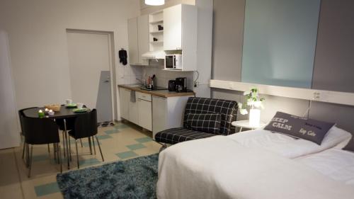 a bedroom with a bed and a table and a kitchen at Yömyssy Apartments in Kerimäki