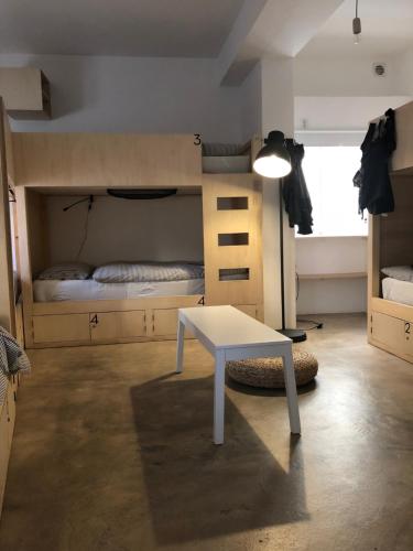 a room with a table and a bunk bed at Hostel do Mar in Carrapateira