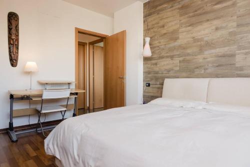 a bedroom with a white bed and a desk at Appartamento Gassman - Holiday Apartment in Milano in Milan