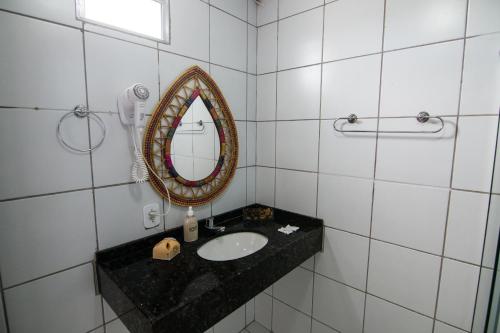 a bathroom with a sink and a mirror at Hotel Gogó da Ema in Maceió