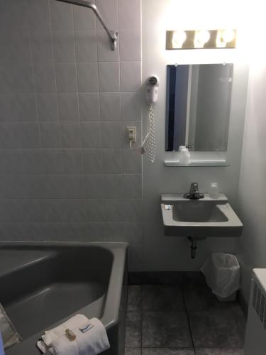 a bathroom with a bath tub and a sink at Advantage Motel in Kapuskasing