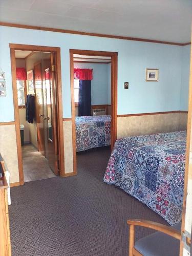 um quarto de hotel com duas camas e um espelho em The Monarch Motel em Cheboygan