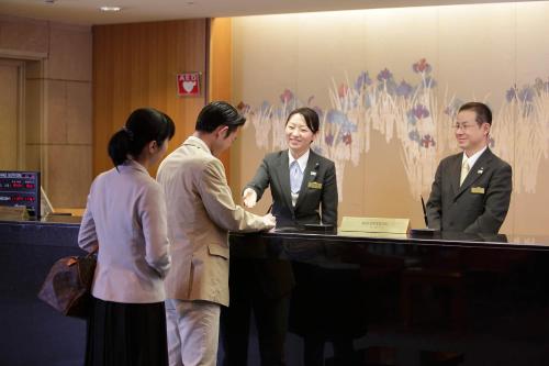 a group of people standing around a reception desk at Hotel Hamatsu in Koriyama