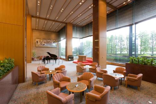 a lobby with a piano and tables and chairs at Hotel Hamatsu in Koriyama