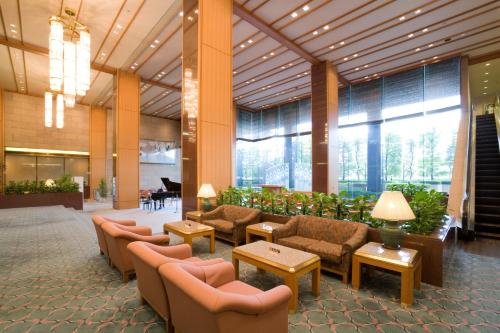 a lobby with couches and tables in a building at Hotel Hamatsu in Koriyama