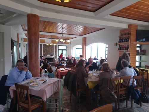 a group of people sitting at tables in a restaurant at Elikonio in Agia Anna