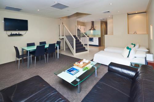 
a living room filled with furniture and a tv at Best Western Plus Hotel Stellar in Sydney
