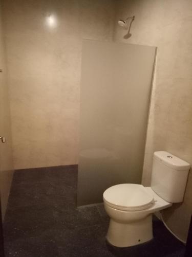 a bathroom with a white toilet in a room at Umah Dajane Guest House in Ubud