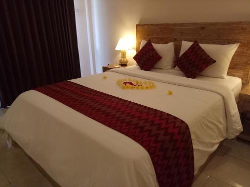 a hotel room with a large white bed with at Umah Dajane Guest House in Ubud