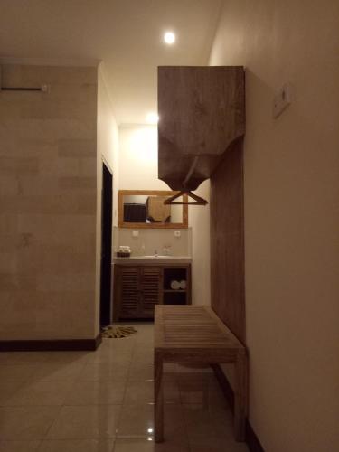 a living room with a bench and a kitchen at Umah Dajane Guest House in Ubud