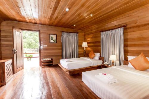 een slaapkamer met twee bedden en een houten plafond bij Angkor Heart Bungalow in Siem Reap