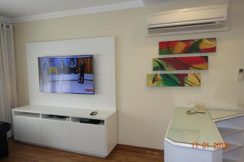 sala de estar con TV en la pared en Flat luxuoso no centro comercial Faria Lima, en São Paulo
