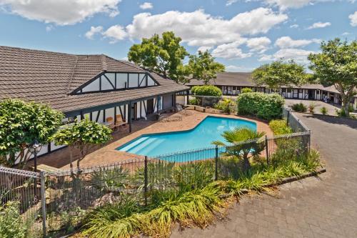 an image of a house with a swimming pool at Oakwood Manor Motor Lodge in Auckland