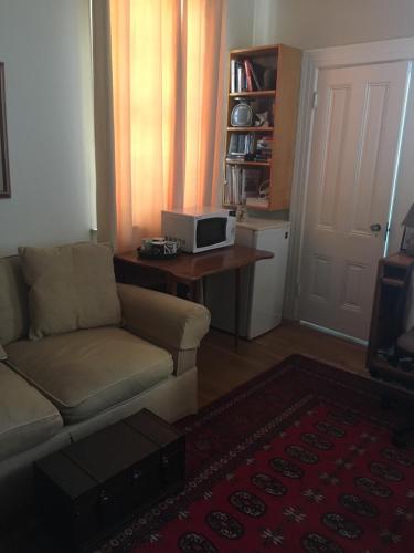a living room with a couch and a table with a microwave at SWEET Suite BAKER Street in San Francisco