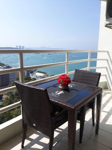 a table and chairs on a balcony with a view of the ocean at View Talay6 Mark Apartments in Pattaya