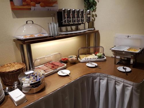 a kitchen counter with food on a table at Hotel KRONE Garni in Deckenpfronn
