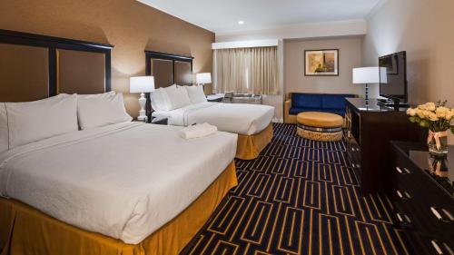 Best Western Plus Palm Court Hotel tesisinde bir odada yatak veya yataklar