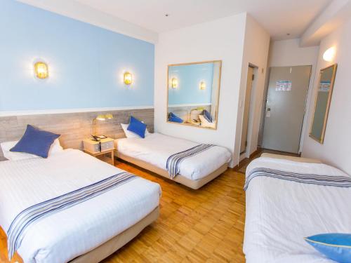 a hotel room with two beds and a mirror at Hotel AreaOne Sakaiminato Marina in Sakaiminato