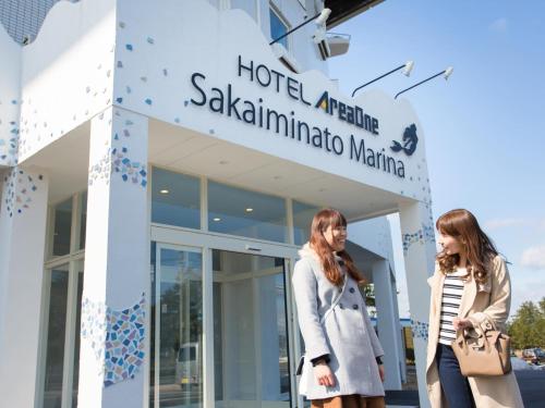 two women walking in front of a building at Hotel AreaOne Sakaiminato Marina in Sakaiminato