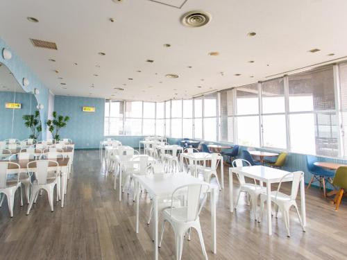 a dining room with white tables and chairs at Hotel AreaOne Sakaiminato Marina in Sakaiminato