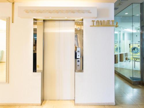 a elevator in a store with a sign on the wall at Hotel AreaOne Sakaiminato Marina in Sakaiminato