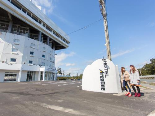 two women standing next to a sign on a street at Hotel AreaOne Sakaiminato Marina in Sakaiminato