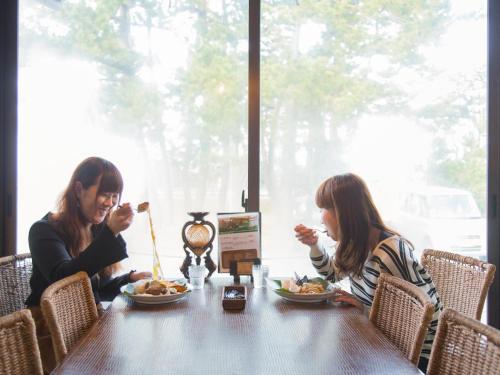 two women sitting at a table eating food at Hotel AreaOne Sakaiminato Marina in Sakaiminato