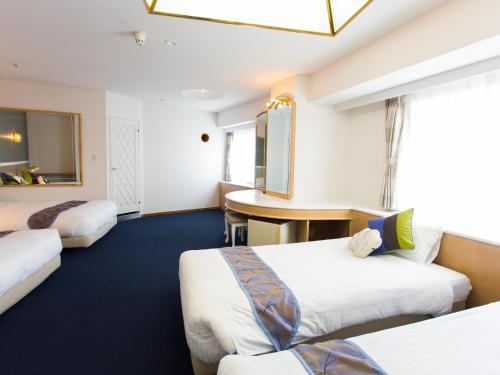 a hotel room with two beds and a desk at Hotel AreaOne Sakaiminato Marina in Sakaiminato