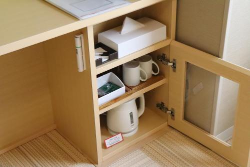 a cupboard with a printer and mugs in it at Hiyori Hotel Maihama in Urayasu