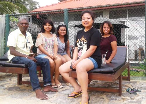 a group of people sitting on a bench at Randiya Beach Villa in Galle