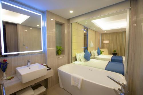Grand Palace Hotel في يانغون: حمام مع حوض وسرير وحوض استحمام