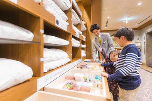 Una mujer y un niño parados en una tienda en Hiyori Hotel Maihama, en Urayasu