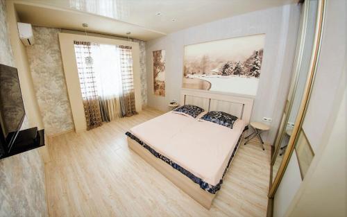a bedroom with a bed and a painting on the wall at ATLANT Apartments 109 in Voronezh
