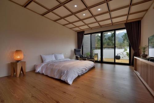 a bedroom with a large bed and a large window at Shan Yi Fang Resort in Yuanshan