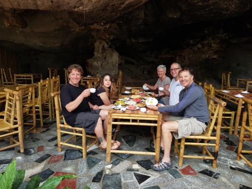 a group of people sitting at a table in a cave at Tam Coc Horizon Bungalow in Ninh Binh