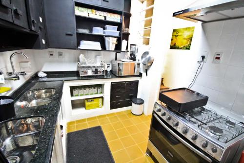 a kitchen with a sink and a stove at Rio Deal Guest House in Rio de Janeiro