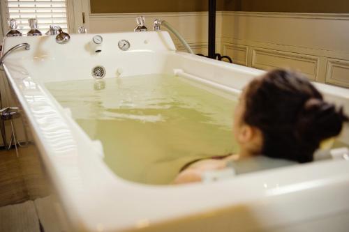 a woman sitting in a bath tub filled with water at Arcadia Hotel - Marina Regia Residence in Mamaia Sat/Năvodari
