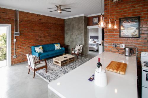 a kitchen and living room with a blue couch at Rustic Retreat Apartment in Durbanville in Durbanville