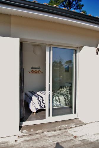 a room with a sliding glass door with a bed at Villa Donosti Chambres d'Hôtes in Lanton