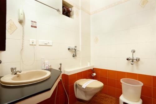 a bathroom with a sink and a toilet at Sri Aarvee Hotels in Coimbatore