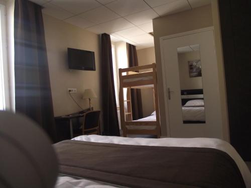 Ένα ή περισσότερα κρεβάτια σε δωμάτιο στο Logis Hotel des Bourbons Montluçon Climatisé