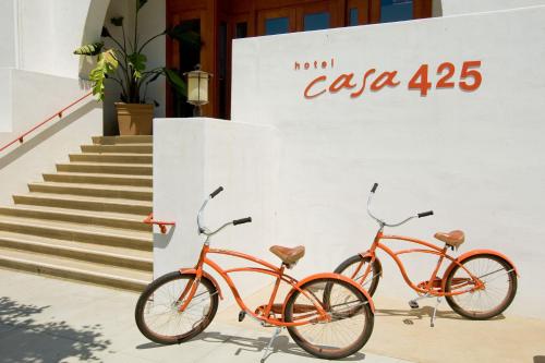 two orange bikes parked next to a wall at Hotel Casa 425 + Lounge, A Four Sisters Inn in Claremont
