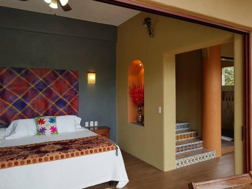 a bedroom with a bed and a surfboard on the wall at Casa Arcoiris Zihuatanejo B&B in Zihuatanejo