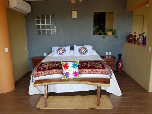 a bedroom with a large bed with pillows on it at Casa Arcoiris Zihuatanejo B&B in Zihuatanejo