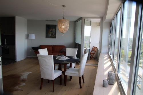 a dining room with a table and white chairs at Ferienappartments Schleswig in Schleswig